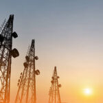 Silhouette, telecommunication towers with TV antennas and satellite dish in sunset